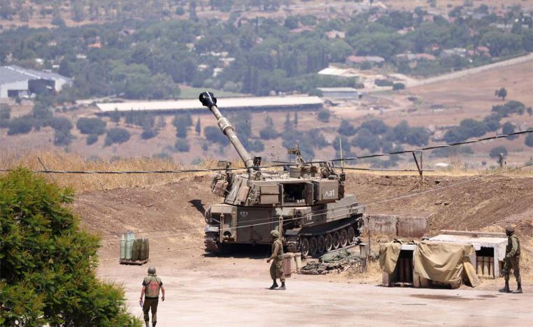 Israeli soldiers stand near an army tank on the outskirts of Kiryat Shmona near Israel's border with Lebanon