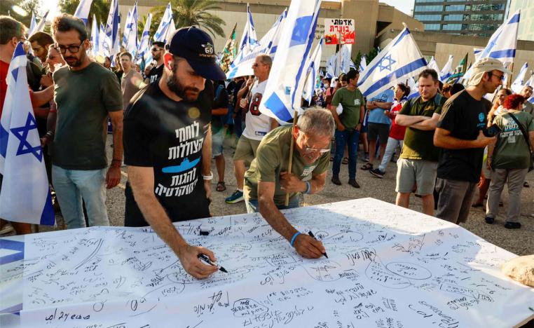 Israeli military reservists sign a declaration announcing the suspension of their voluntary reserve duty