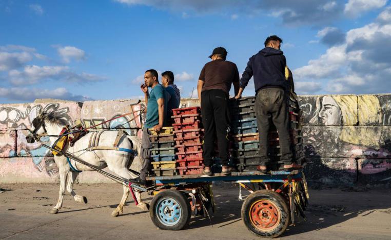 فلسطينيون ينقلون بضائع بعربة يجرها حصان