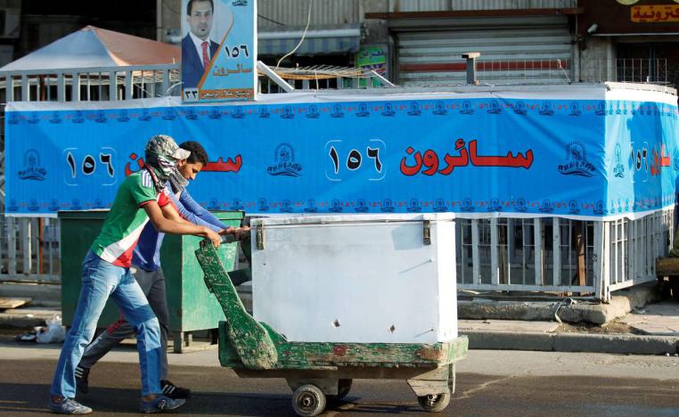 عراقيان يمران بجانب ملصق انتخابي عراقي