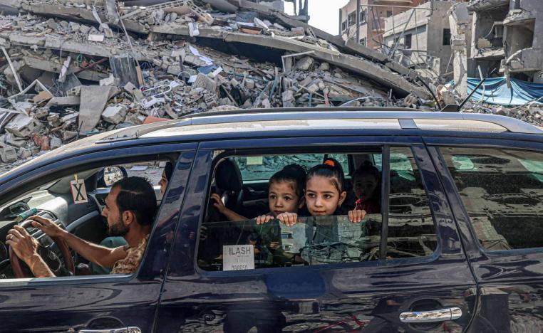 أطفال فلسطينيون في سيارة يغادرون مدينة غزة على خلفية دمار القصف الاسرائيلي