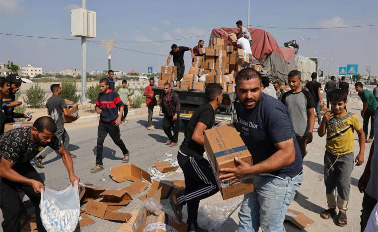 Gazans unpack boxes of humanitarian aid from a truck that entered the southern Gaza Strip from Egypt