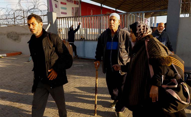 Palestinians with foreign passports arrive at the Rafah border crossing with Egypt