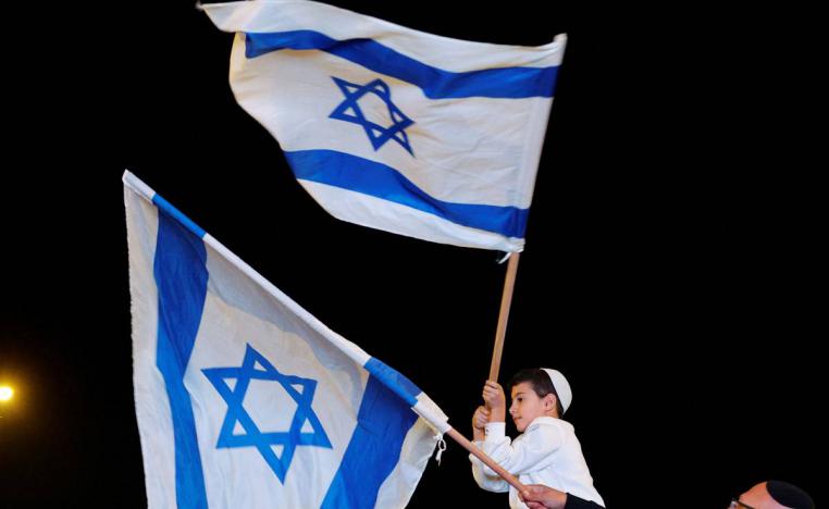 طفل إسرائيلي يرفع اعلاما إسرائيلية في الطريق إلى  كيبوتزات الجنوب المحاذية لغزة
