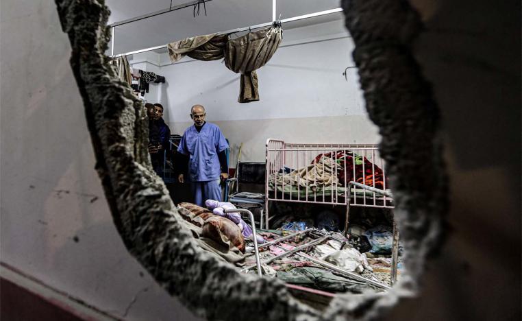 People inspect the damage in a room following Israeli bombardment at Nasser hospital in Khan Younis