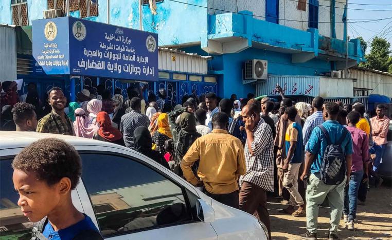 People displaced by war in Sudan gather outside a passport office in city of Gedaref as they attempt to get passports and exit visas after fleeing flee Wad Madani