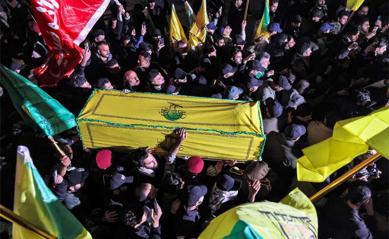 Members of Iraq's Popular Mobilisation Forces (PMF) paramilitaries carry the bodies of two of their slain comrades during their funeral in Baghdad