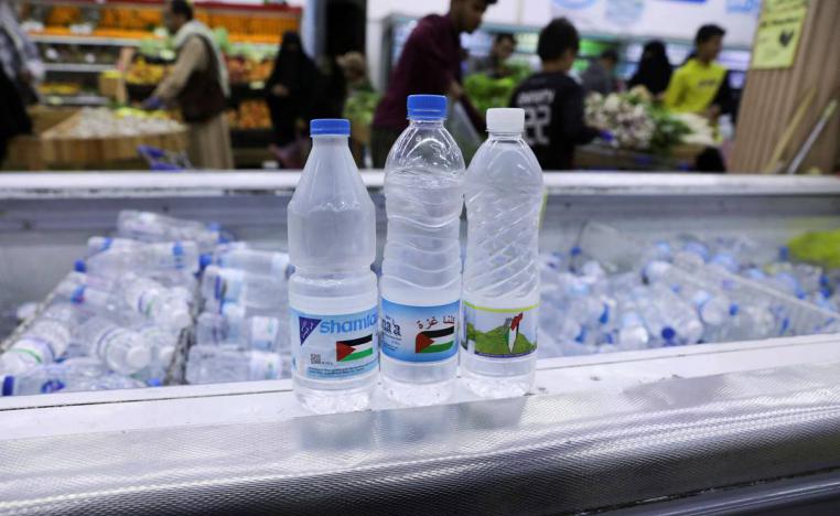 قناني ماء تحمل شعارات تضامن مع غزة في دكان في اليمن