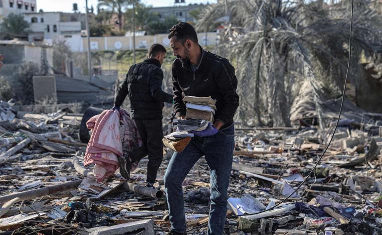 Palestinians search for their belongings amid the rubble of houses destroyed by Israeli bombardment in Rafah