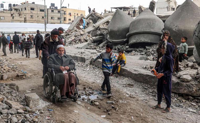 Gazans walk past the rubble of Al-Faruq Mosque that was destroyed during Israeli bombardment in Rafah