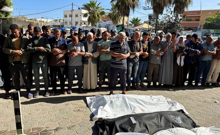 Mourners pray next to the bodies of Palestinians killed in an Israeli strike