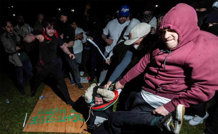 Counter-protesters wielding sticks or poles attacked wooden boards being held up as a makeshift barricade to protect pro-Palestinian protesters