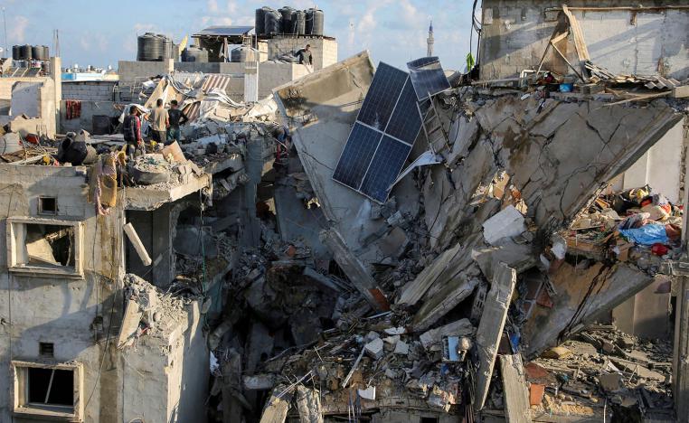 Palestinians inspect the site of an Israeli strike on a house in Rafah