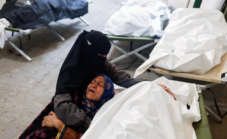 Women mourn next to the bodies of Palestinians killed in Israeli strikes on Rafah