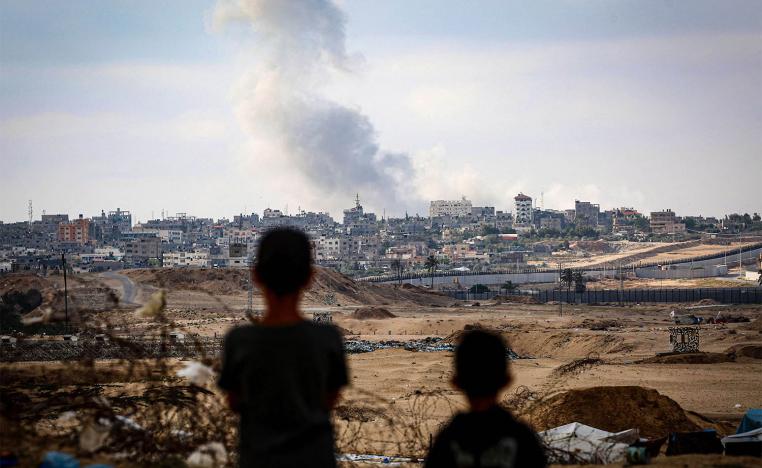 Boys watch smoke billowing during Israeli strikes east of Rafah in the southern Gaza Strip 