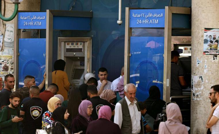 فلسطينيون يسحبون أموالا من مكائن الصرف في نابلس في الضفة الغربية