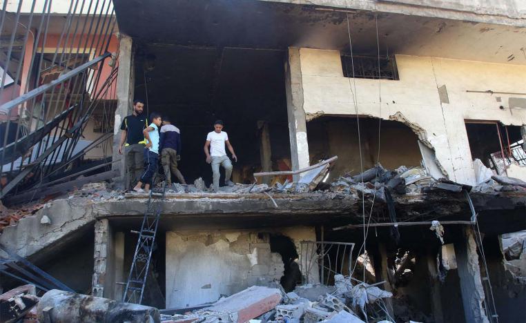 People inspect the debris at the site of an overnight Israeli strike on a house in the southern Lebanese village of Akbiyeh
