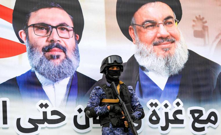 مقاتل حوثي أمام جدارية لحسن نصرالله وهاشم صفي الدين في صنعاء