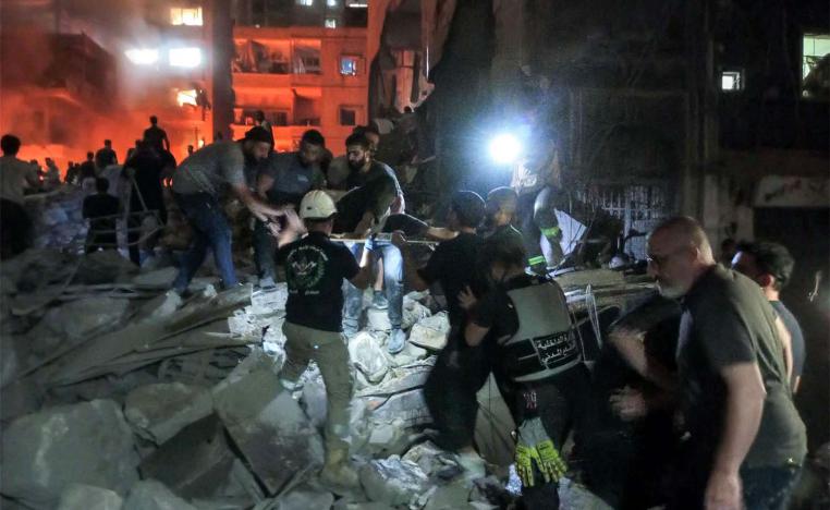 Lebanese civil defence members and other people inspect the site of an Israeli airstrike on the Basta neighbourhood of Beirut
