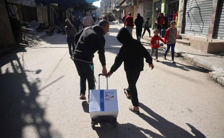 فلسطينيون يسحبون حصتهم من مساعدات دولية في غزة