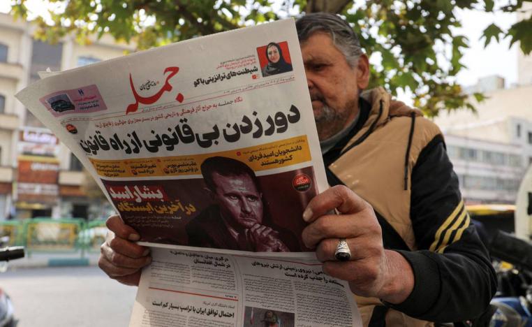 إيراني يتصفح جريدة في طهران