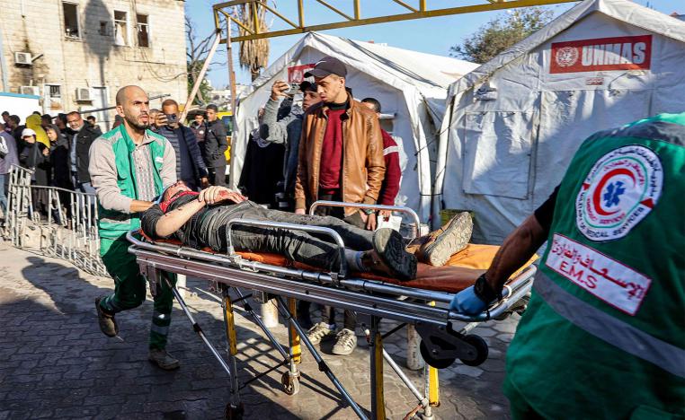 Paramedics transport on a gurney a person who was injured in a reported strike on a Palestinian civilian vehicle by Israeli forces
