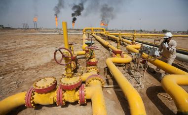 A worker checks an oil pipeline at Nahr Bin Umar oil field, north of Basra