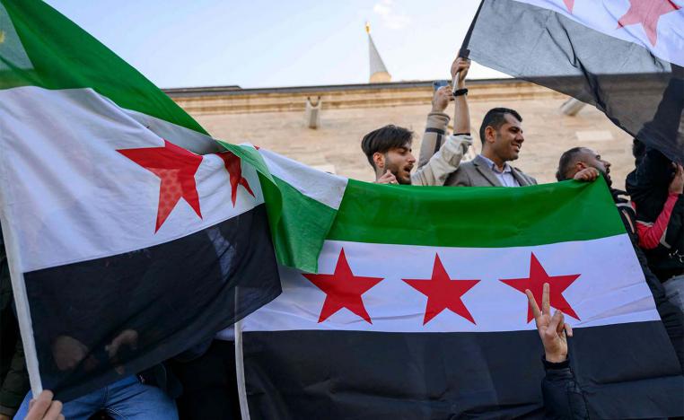Syrian residents in Turkey hold Syrian flags as they celebrate the end of the Baath rule in Syria 
