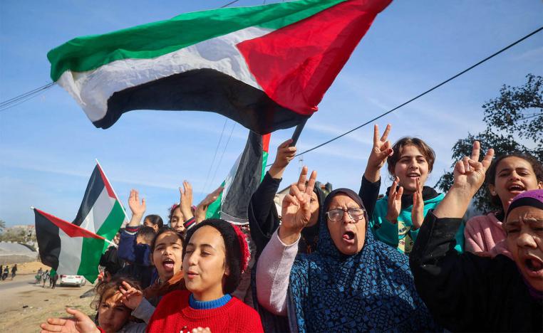 Displaced Palestinians wave national flags as they return to Rafah