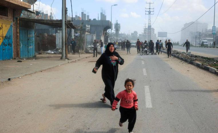 طفلة فلسطينية وأمها تفران من منطقة القصف الإسرائيلي في مخيم النصيرات وسط غزة