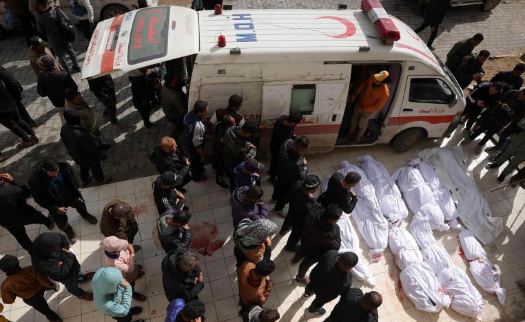 Palestinians recite a prayer over the bodies of victims of Israeli overnight airstrikes in the northern Gaza Strip