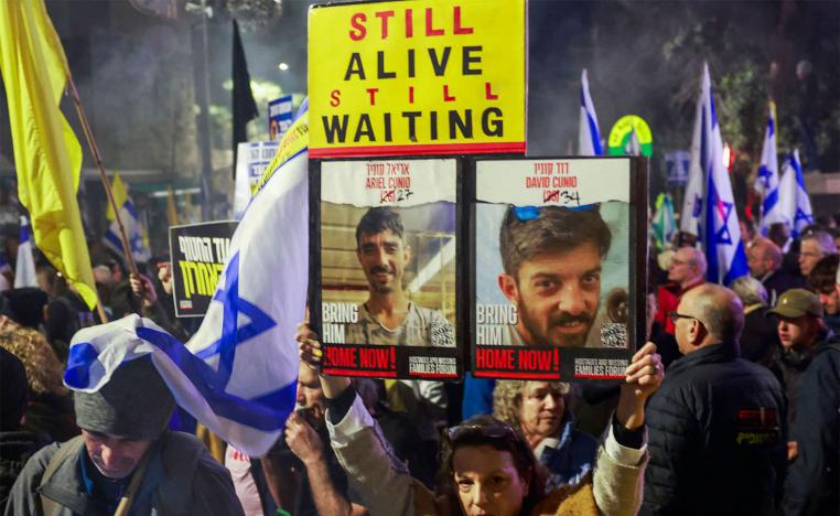 Israeli protesters lift placards during a rally calling on the government for a deal that would bring all the remaining captives back