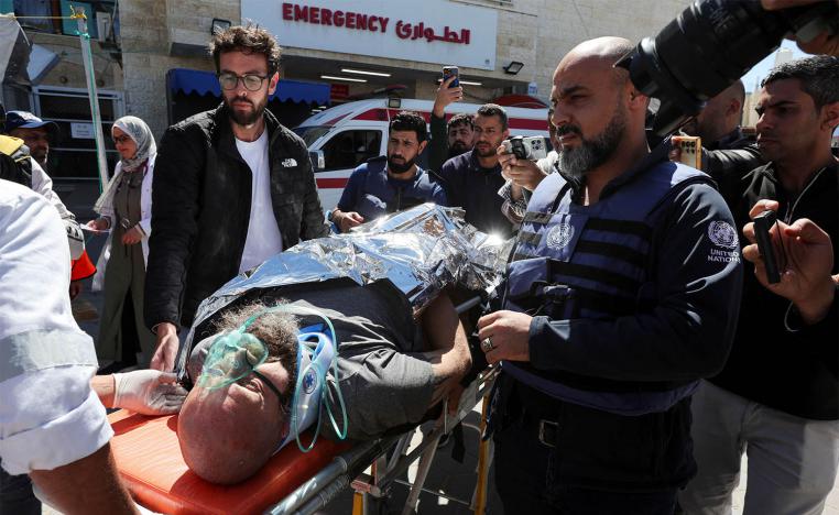 A foreign worker, who was wounded in an Israeli airstrike on a UN headquarters is brought into Al-Aqsa Martyrs hospital, in Deir Al-Balah