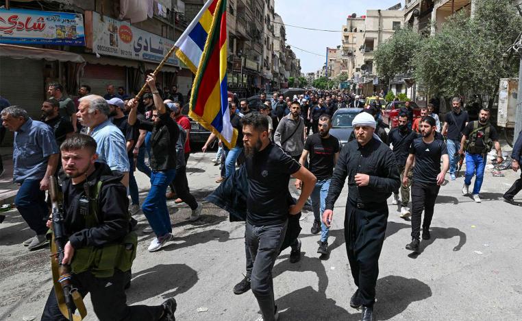 Armed members of Syria's Druze community attend the funeral of seven people killed during overnight clashes with Syrian security forces, in Damascus
