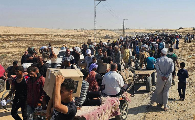 Displaced Palestinians walk along a road to receive humanitarian aid packages from a US-backed foundation in Rafah in the southern Gaza Strip on June 