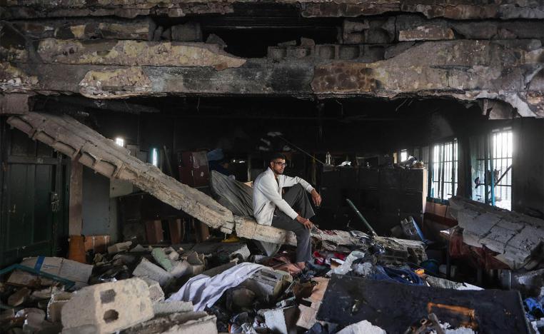 A man sits amid the debris at the Fahmi Al-Jarjawi School in Gaza City on May 26