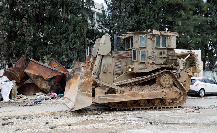 An armored caterpillar bulldozer stands on a street during an Israeli raid at Tulkarm