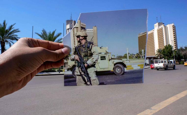 A photograph of a US soldier standing guard in Firdous square in front of the Sheraton (L) and Palestine hotels after they came under attack, July 2, 2004 is inserted into the scene at the same location, March 10, 2023.