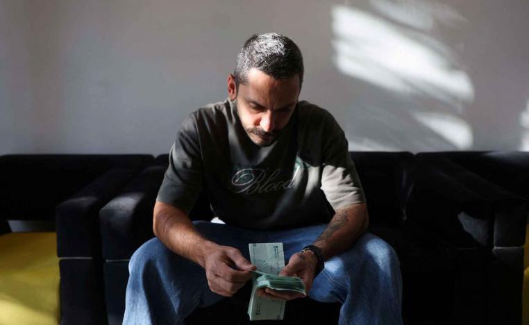 A currency dealer holds Iranian rial bills in Tehran.