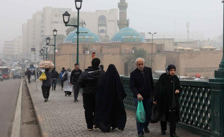 People walk across a bridge during a foggy day in Baghdad, December 11, 2025. 