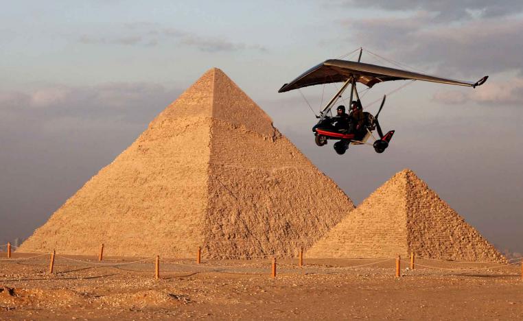 A tourist flies with an Ultralight trike pilot near the Great Pyramids of Giza, on the outskirts of Cairo.