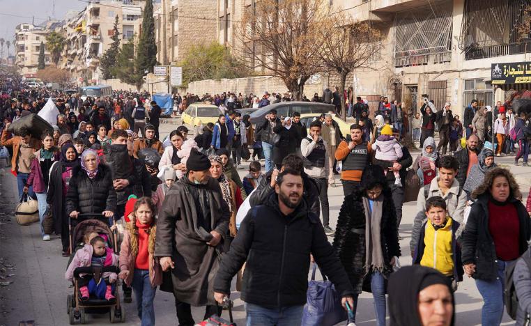 Civilians carry their bags and belongings as they flee following renewed clashes between the Syrian army and the Syrian Democratic Forces in Aleppo