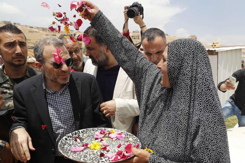 Gebran Bassil (C) is greeted with flower petals at a Syrian refugee camp in the town of Arsal on the eastern border with Syria.
