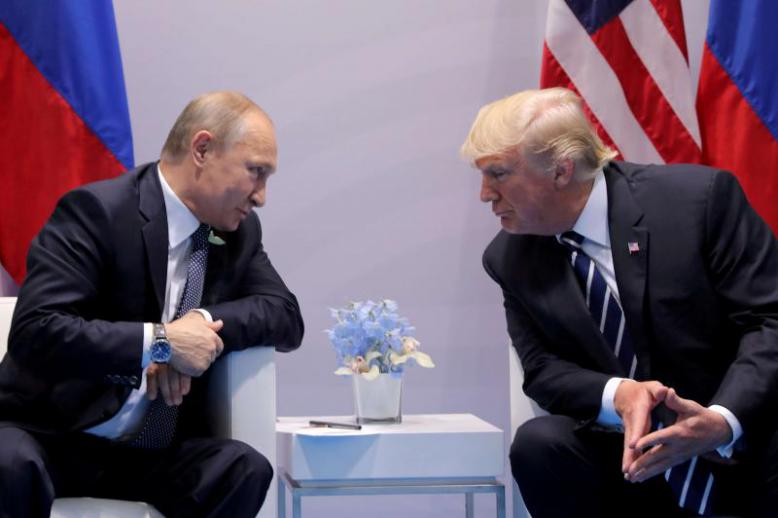 Russian President Vladimir Putin (L) talks to US President Donald Trump during their meeting at the G20 summit in Hamburg, last July