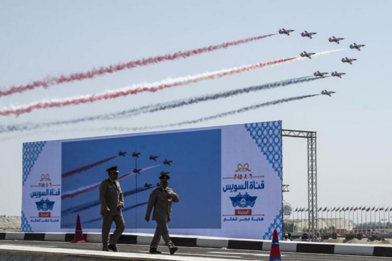 A file picture shows Egyptian Army officers walking in front of a huge screen during the opening ceremony of a waterway at the Suez Canal in Ismailia
