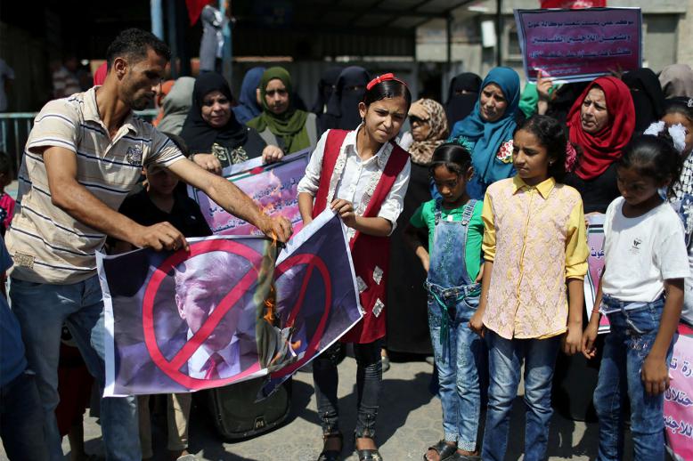 Palestinians burn Donald Trump's picture during a protest against a US decision to cut funding to UNRWA