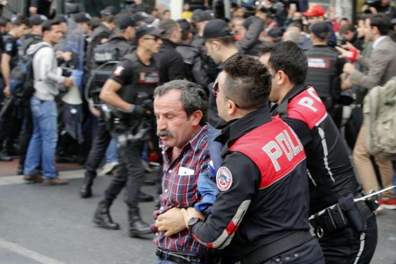 Police officers detain a Turkish man during protests in Istanbul, last May