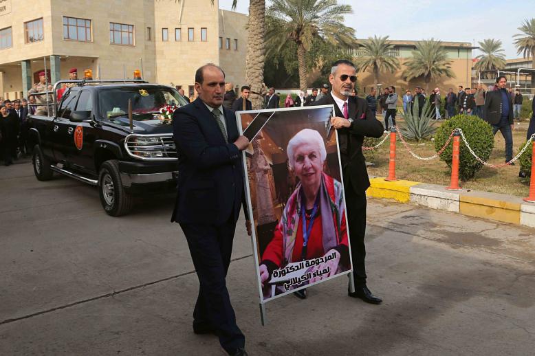 Mourners transport the flag-draped coffin of Iraqi archaeologist, Lamia al-Gailani, seen in the poster, for burial during her funeral procession in the National Museum in Baghdad, Iraq, Monday, Jan. 21, 2019