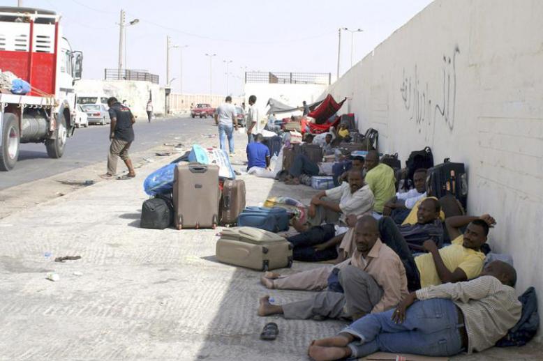 Another useless wall? Sudanese workers rest as they wait for Egyptian visas next to the Libyan-Egyptian border crossing in Musaid.