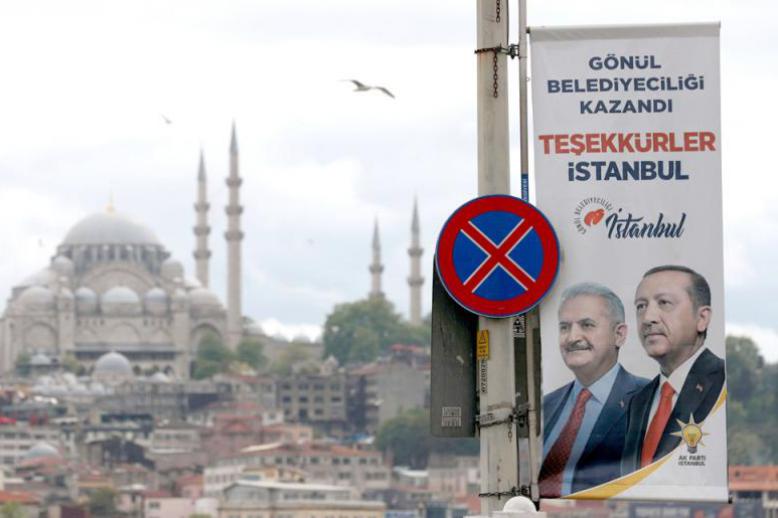 An election banner with pictures of Turkish President Recep Tayyip Erdogan and ruling party mayoral candidate Binali Yildirim is seen over the Galata bridge in Istanbul